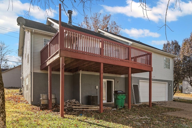 rear view of property with a garage, central AC unit, and a wooden deck