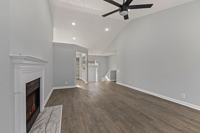 unfurnished living room featuring lofted ceiling, ceiling fan, a premium fireplace, a textured ceiling, and dark hardwood / wood-style flooring