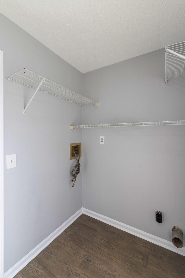 laundry area featuring dark wood-type flooring, a textured ceiling, and washer hookup