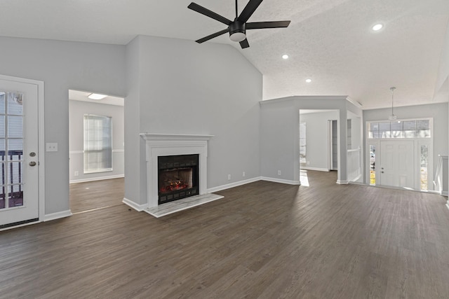 unfurnished living room with a textured ceiling, high vaulted ceiling, ceiling fan, and dark wood-type flooring