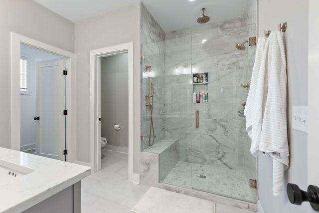 bathroom featuring tile patterned flooring, vanity, a shower with shower door, and toilet