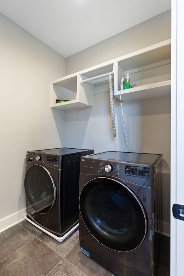 clothes washing area featuring tile patterned flooring and separate washer and dryer