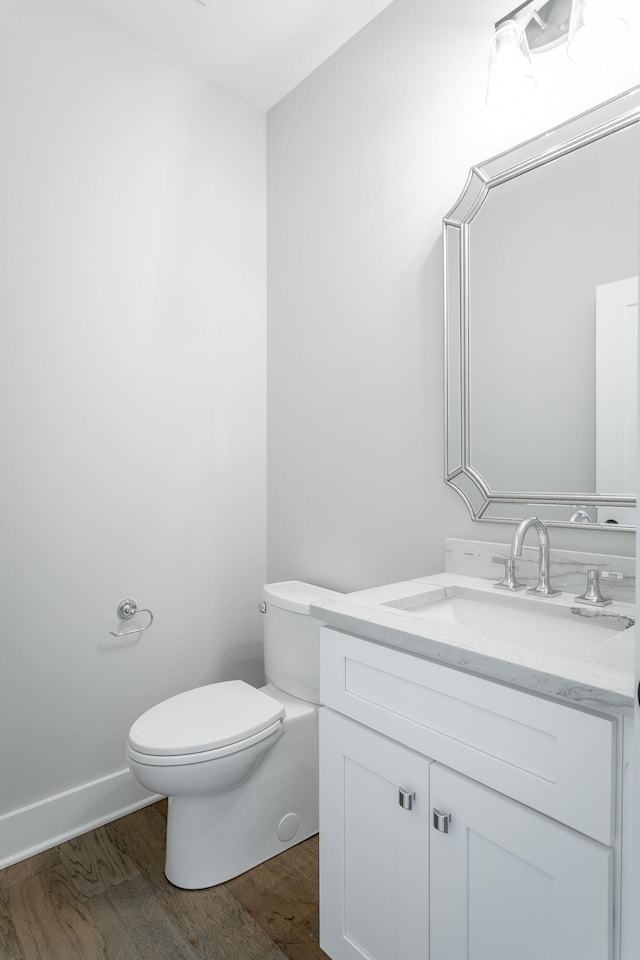 bathroom featuring vanity, hardwood / wood-style flooring, and toilet