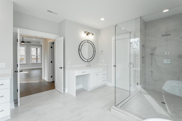 bathroom with ceiling fan, vanity, and a shower with door