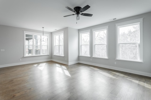 unfurnished room with dark wood-type flooring and ceiling fan with notable chandelier