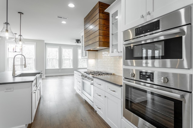 kitchen with stainless steel appliances, tasteful backsplash, sink, and white cabinets