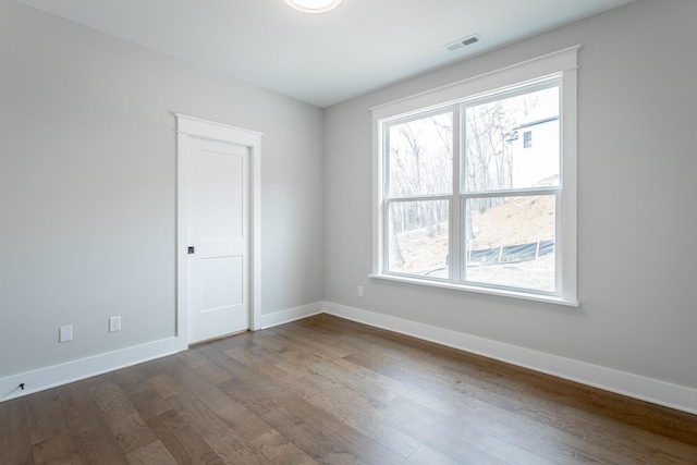 unfurnished room with hardwood / wood-style flooring and a healthy amount of sunlight