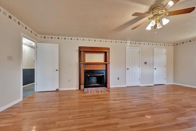 unfurnished living room with a textured ceiling, ceiling fan, and light hardwood / wood-style floors