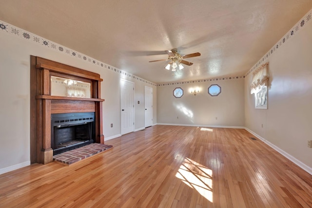 unfurnished living room with a textured ceiling, ceiling fan, and hardwood / wood-style floors