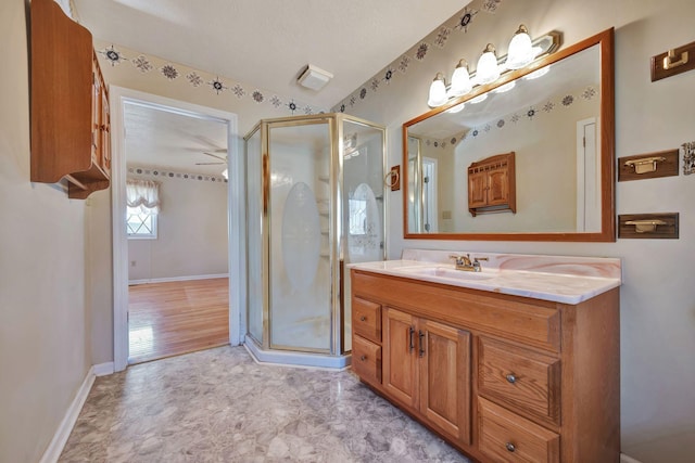 bathroom featuring a shower with door, vanity, a textured ceiling, and ceiling fan