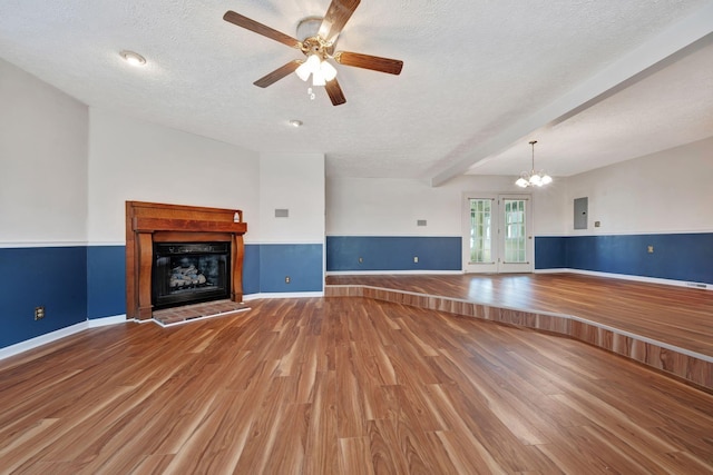 unfurnished living room with wood-type flooring, electric panel, a textured ceiling, beam ceiling, and ceiling fan with notable chandelier