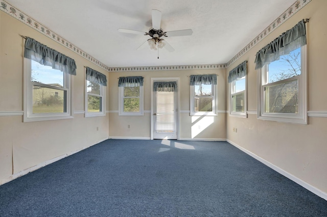 unfurnished sunroom with ceiling fan