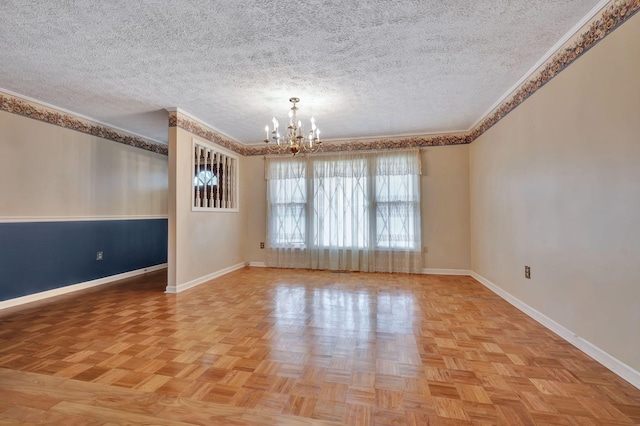 empty room featuring light parquet flooring, an inviting chandelier, ornamental molding, and a textured ceiling