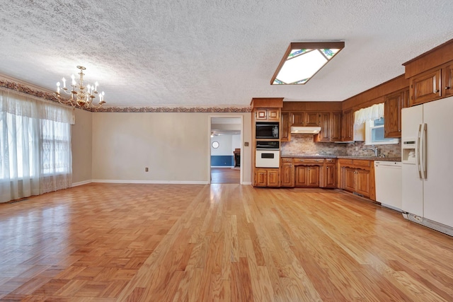 kitchen featuring white appliances, a chandelier, light hardwood / wood-style floors, decorative backsplash, and decorative light fixtures