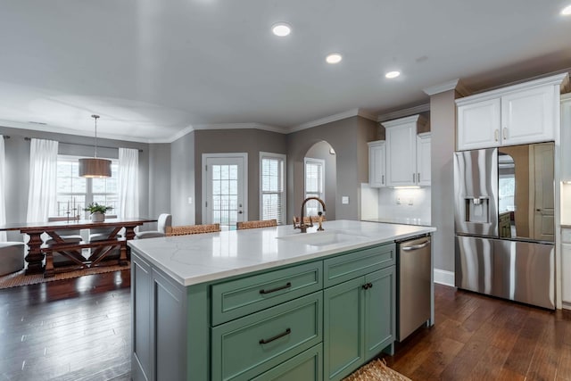 kitchen with appliances with stainless steel finishes, sink, green cabinetry, white cabinets, and an island with sink