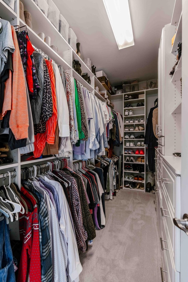 walk in closet featuring light colored carpet