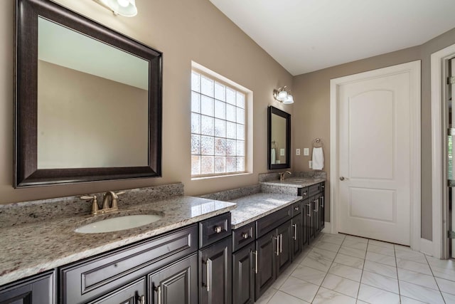 bathroom featuring vanity and lofted ceiling