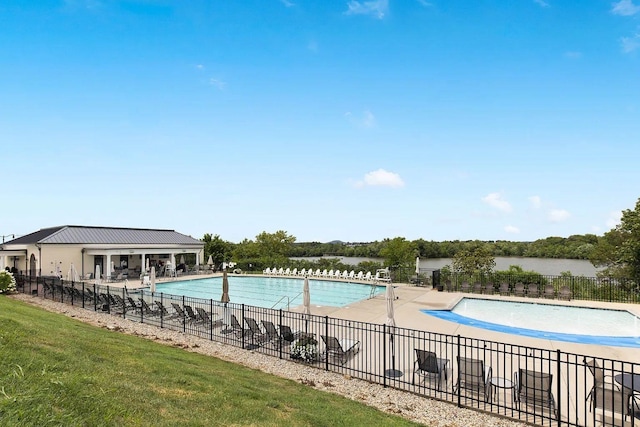 view of pool with a water view and a patio area