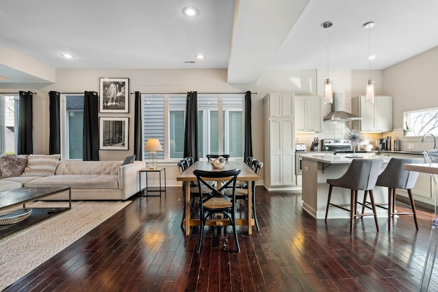 living room with plenty of natural light and dark wood-type flooring