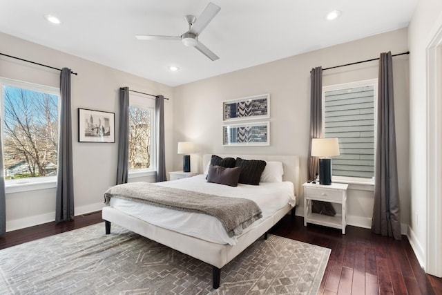 bedroom with multiple windows, ceiling fan, and dark wood-type flooring