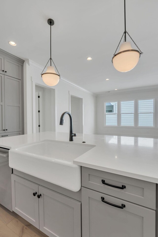 kitchen featuring a sink, ornamental molding, gray cabinets, and dishwasher