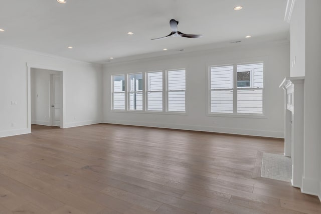 unfurnished living room with ceiling fan, ornamental molding, and wood finished floors