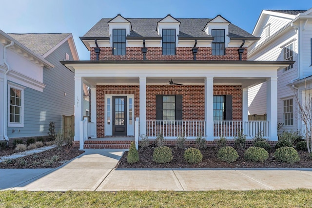 view of front of home with a porch, brick siding, and a shingled roof