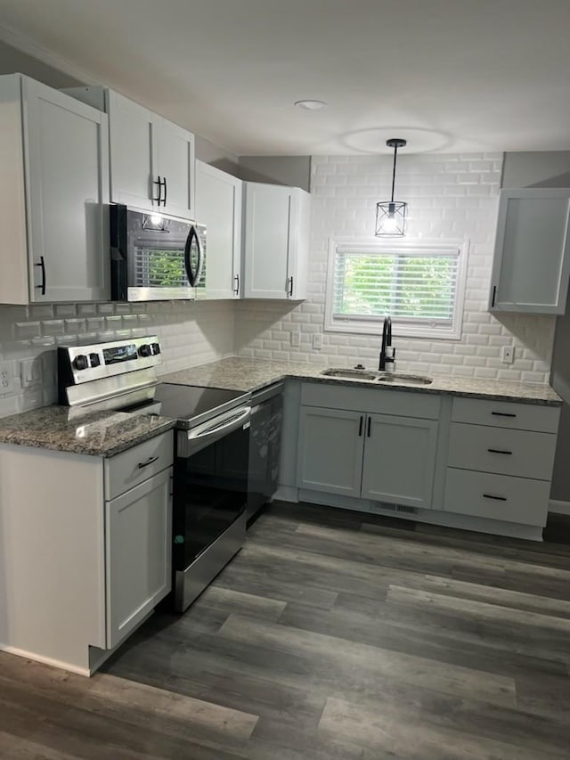 kitchen featuring pendant lighting, sink, appliances with stainless steel finishes, and dark wood-type flooring