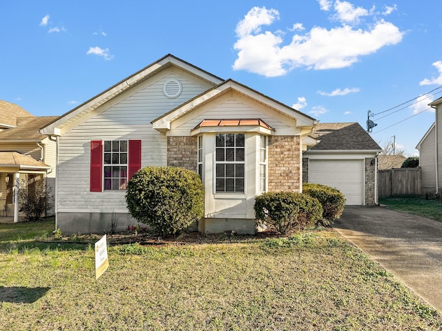 view of front of house featuring brick siding, an attached garage, fence, driveway, and a front lawn