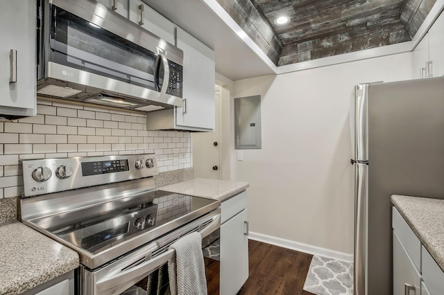 kitchen with dark wood-type flooring, tasteful backsplash, electric panel, white cabinets, and appliances with stainless steel finishes