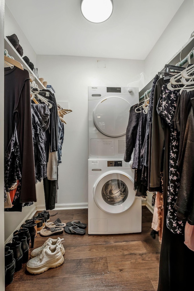 laundry area with stacked washer / dryer and hardwood / wood-style floors