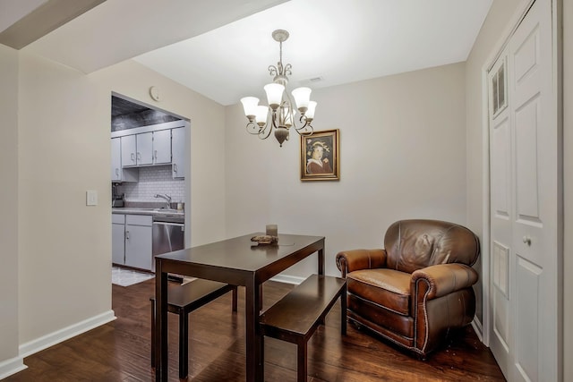 dining space with dark hardwood / wood-style floors, an inviting chandelier, and sink