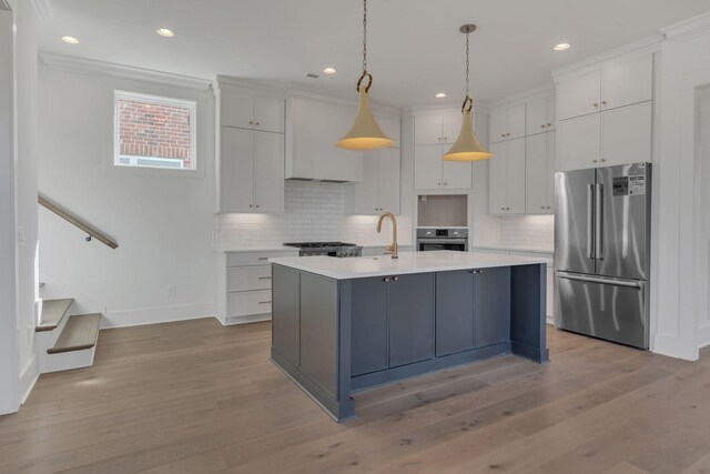 kitchen with stainless steel appliances, light countertops, light wood-style flooring, white cabinetry, and premium range hood