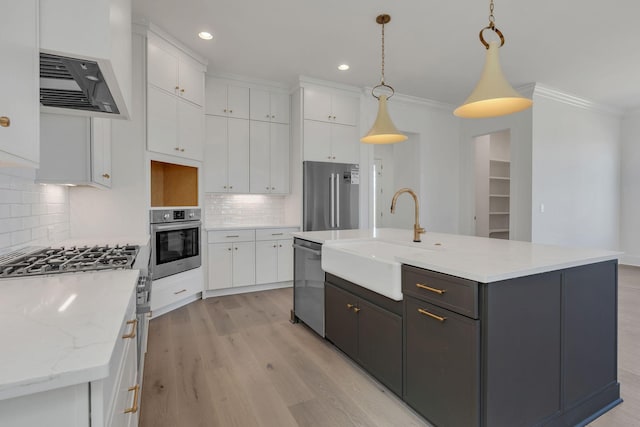 kitchen featuring stainless steel appliances, white cabinetry, a sink, and crown molding