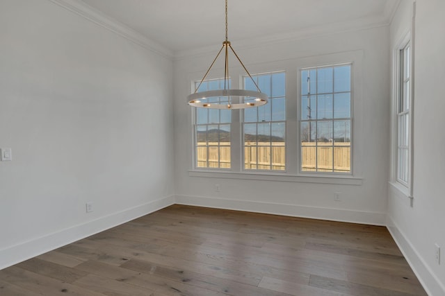 unfurnished dining area featuring baseboards, an inviting chandelier, dark wood finished floors, and crown molding