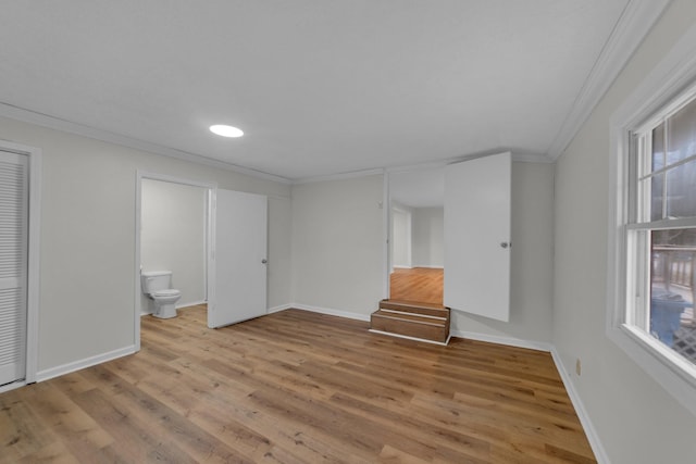 unfurnished bedroom with ensuite bathroom, light hardwood / wood-style flooring, and ornamental molding