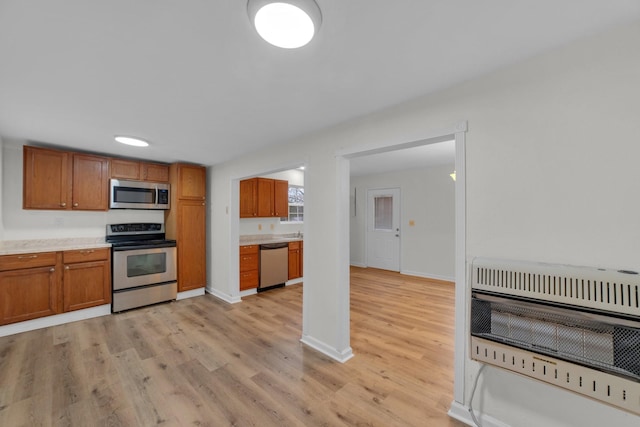 kitchen featuring appliances with stainless steel finishes, heating unit, and light hardwood / wood-style flooring