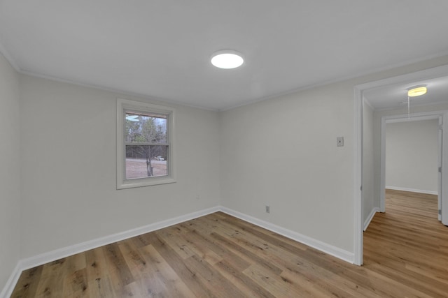 spare room featuring light wood-type flooring and ornamental molding