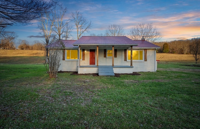 view of front of house with covered porch and a yard