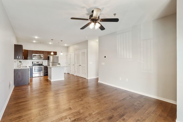 unfurnished living room with hardwood / wood-style floors, ceiling fan, and sink