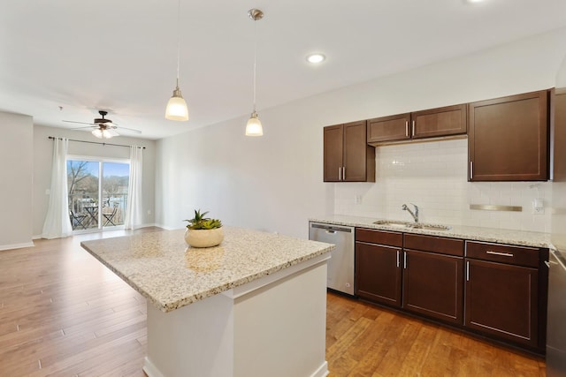 kitchen featuring pendant lighting, dishwasher, light hardwood / wood-style floors, and sink