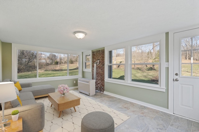 unfurnished sunroom with heating unit and a wealth of natural light