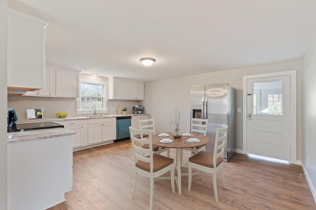 kitchen with white cabinets, stainless steel appliances, light hardwood / wood-style floors, and sink