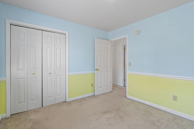 unfurnished bedroom featuring a closet and light colored carpet