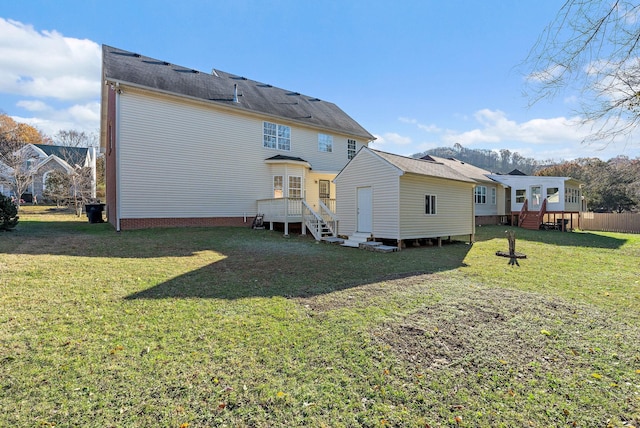 rear view of house with a yard and a wooden deck