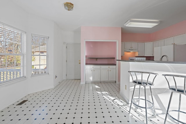 kitchen with gray cabinetry and white fridge