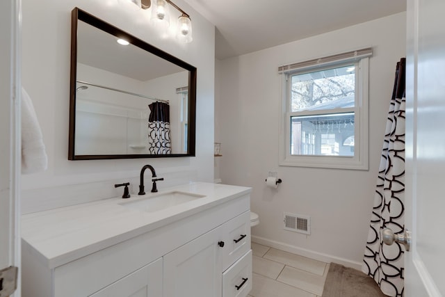 bathroom with tile patterned flooring, vanity, and toilet