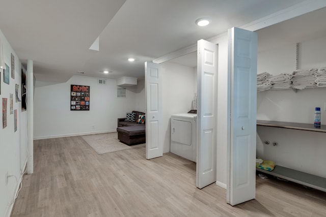 clothes washing area featuring washer / dryer and light hardwood / wood-style floors