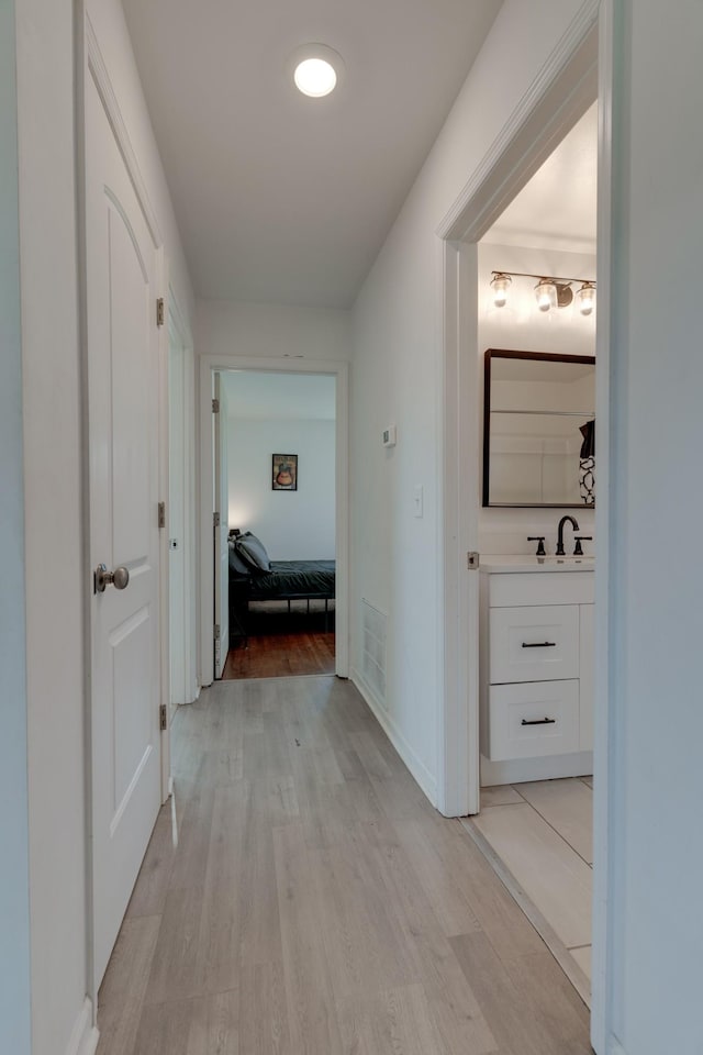 hallway featuring light wood-type flooring and sink