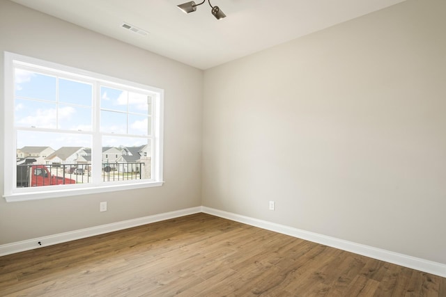 empty room featuring a wealth of natural light and hardwood / wood-style floors